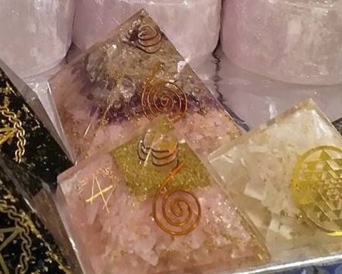 Flera orgonit pyramider med olika stenar och symboler i metall.